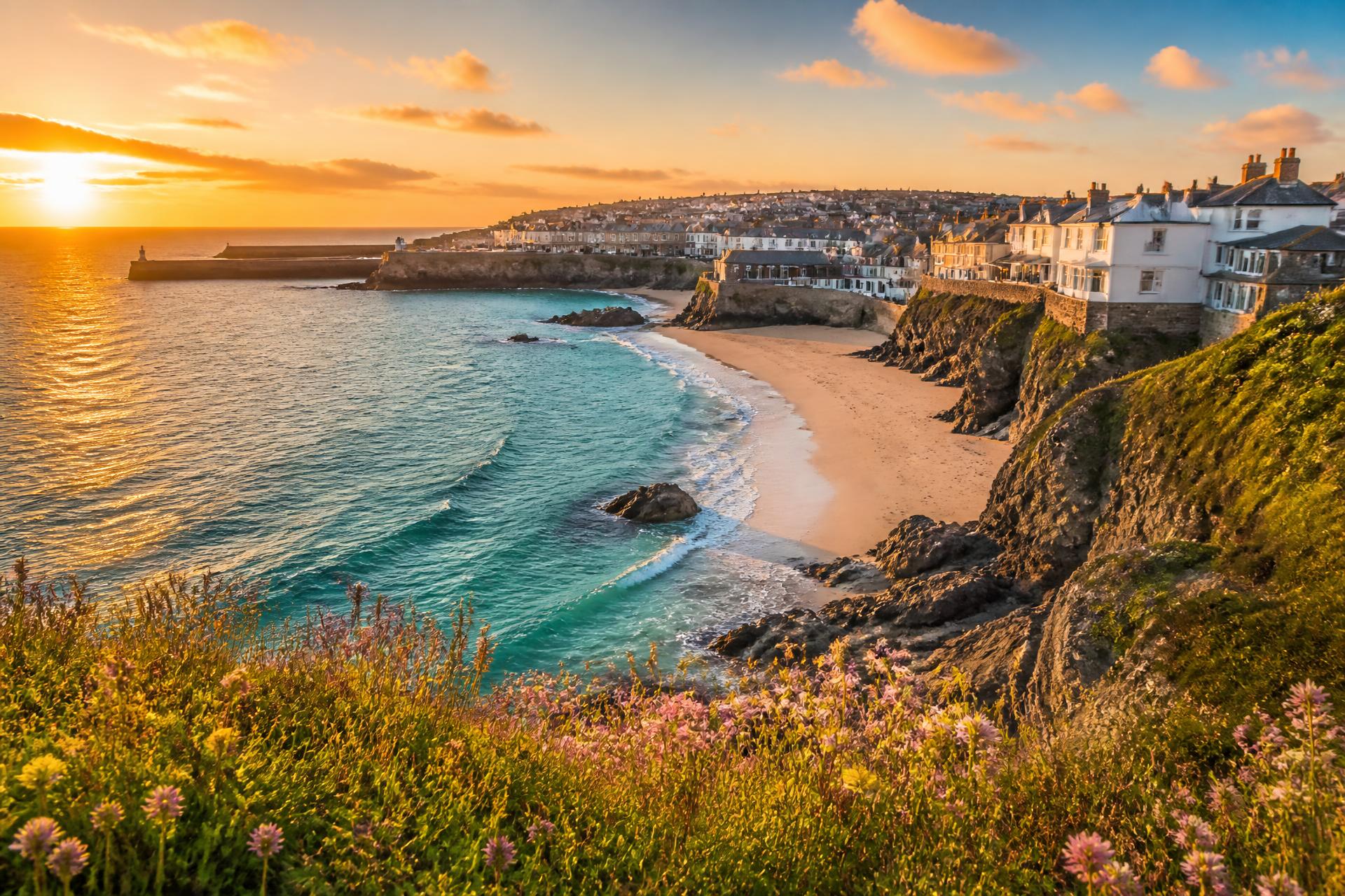 Cornish coast at sunset with turquoise water and wildflowers above St Ives